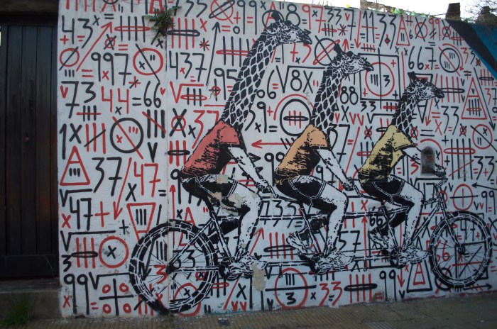Giraffes riding bicycles over a collaboration piece